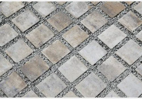 Betonové zatravňovací dlaždice v šachovnicovém vzoru s kamínky.