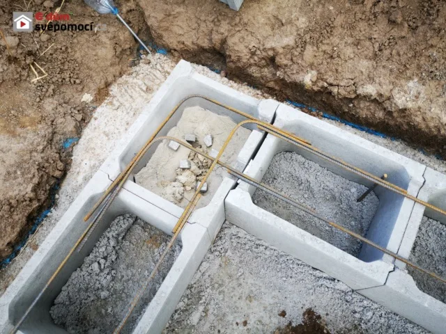 Ztracené bednění s výztuží pro betonovou základnu v procesu stavby.