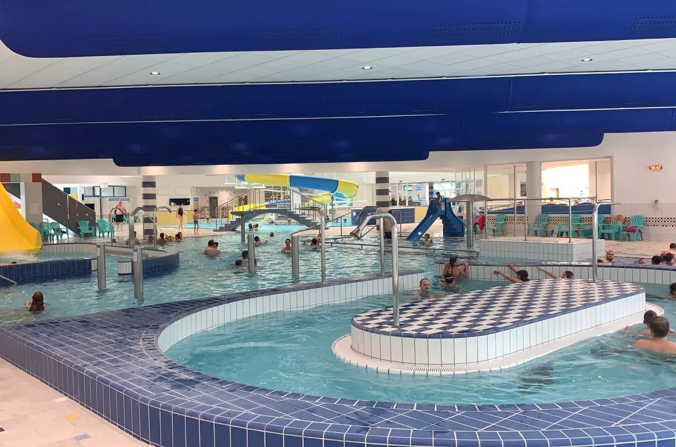 Indoor swimming pool with slides and people