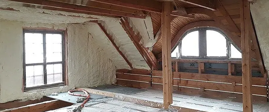 Zateplovací pěna se aplikuje na stěny a trámy v podkroví.