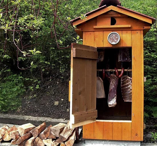 Wooden smokehouse with hanging meat