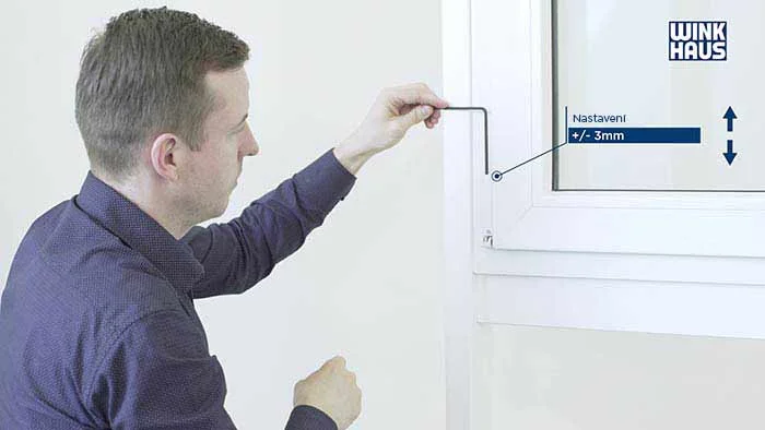Muž nastavuje plastové okno pomocí nástroje podle návodu.
