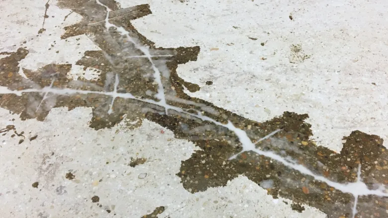 Příprava podlahy samonivelačním betonem s viditelnými trhlinami.