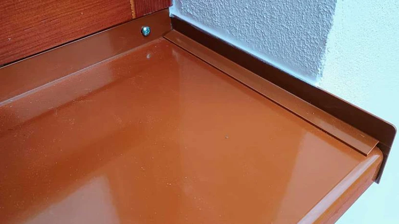 Hnědý vnitřní parapet nainstalovaný ve výklenku okna.