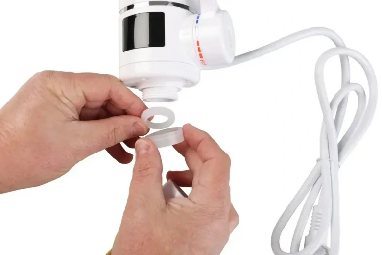 Ruční instalace těsnění na podstavec elektrického ohřívače vody.