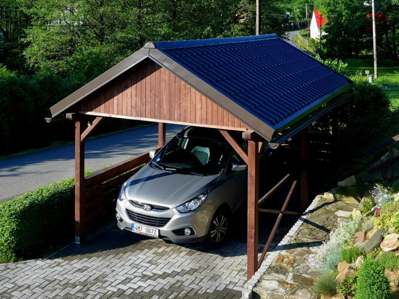 Přístřešek pro auto s dřevěným rámem a tmavou střechou.