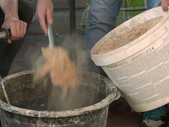 Přesun dřevních štěpků do míchací nádoby pro výrobu briket.