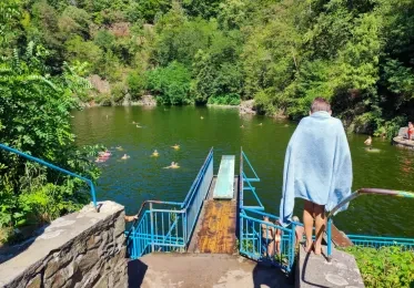 Koupaliště v lomu s bazénem uprostřed zelené přírody.
