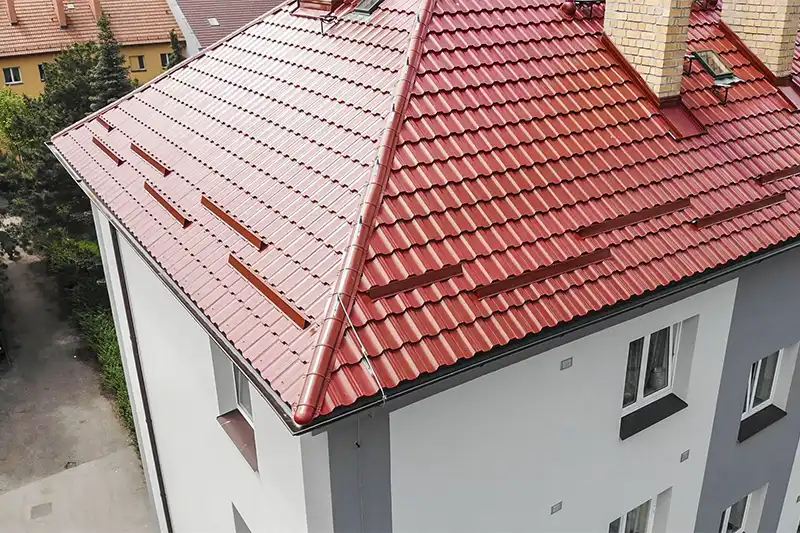 Nově rekonstruovaná červená střecha s krovem na obytném domě.