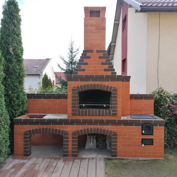 Velký zahradní krb z cihel s komínem pro vaření pizzy.