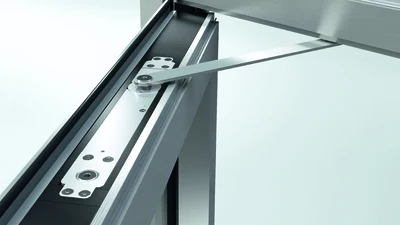 Detailní pohled na kovový úchytný mechanismus pro protipožární dveře.