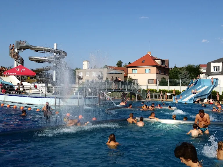 Venkovní bazén s vodními skluzavkami a plavci v Nové Pace
