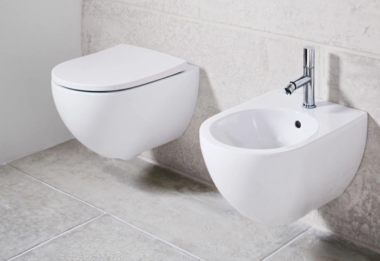Zdi montovaný bidet vedle zdi montovaného WC v koupelně.