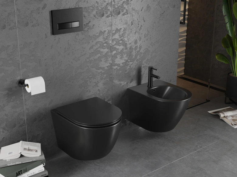 Černý bidet nainstalovaný vedle zdi s WC v šedé koupelně.