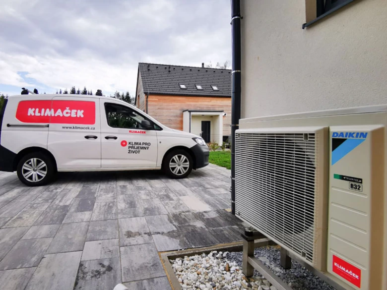 Klimatizační jednotka s servisním vozem značky KLIMAČEK u domu.