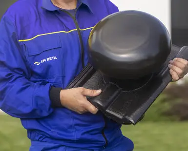 Pracovník drží malty pro zdění cihel s kladivem.