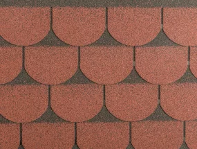 Detailní záběr na červenohnědý asfaltový šindel s vlnitým okrajem.