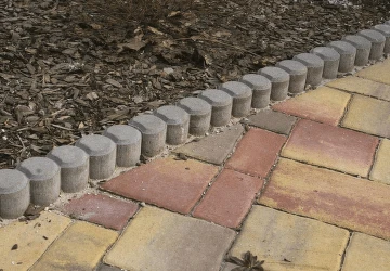 Betonové obrubníky jsou položeny mezi dlažbou a zemí.