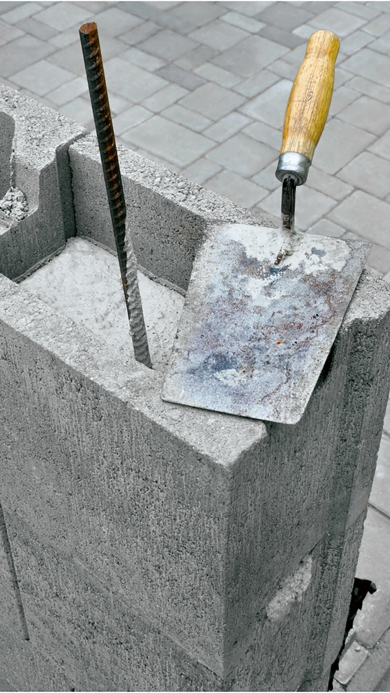 betonový blok s výztuží a stavebními nástroji