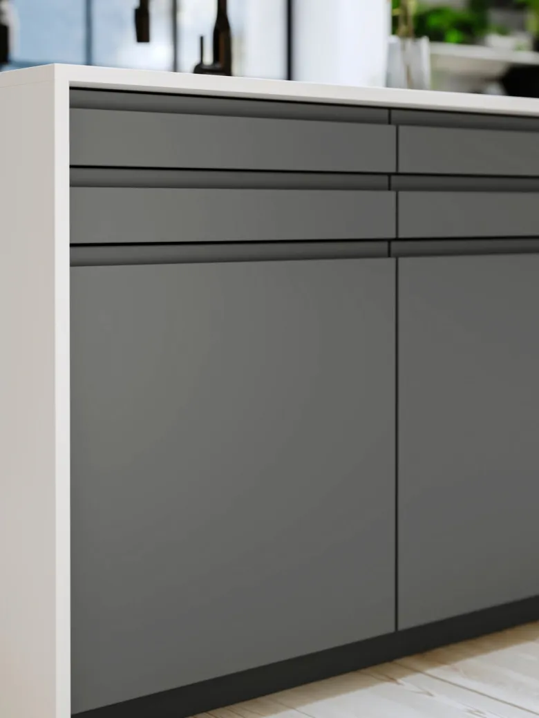 Moderní šedé kuchyňské skříňové dvěřnice s bílou pracovní deskou.