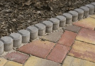 Betonové obrubníky lemovající dlažbu v zahradě.