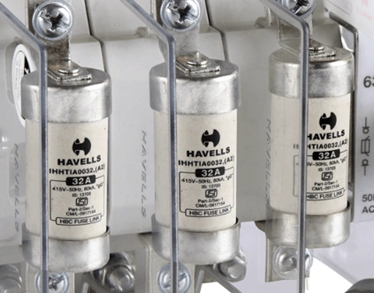 Tři pojistky Havells v držáku pro elektrické sítě.