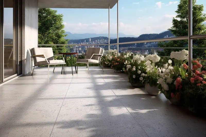 Moderní terasa s kamínkovou podlahou, květinami a výhledem na město.