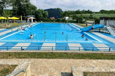 Venkovní bazén v Otrkovicích s plavci a skluzavkou