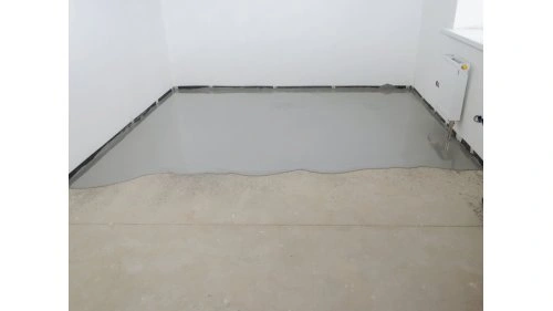 Světle šedá samonivelační stěrka na podlaze v nezařízené místnosti.