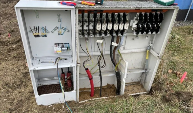 Otevřený elektroměrový rozvaděč s viditelnými pojistkami a propojením vodičů.