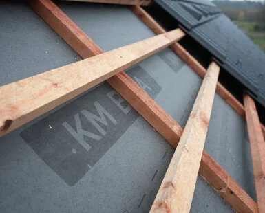 Dřevěné trámy na střeše nad hydroizolační fólií
