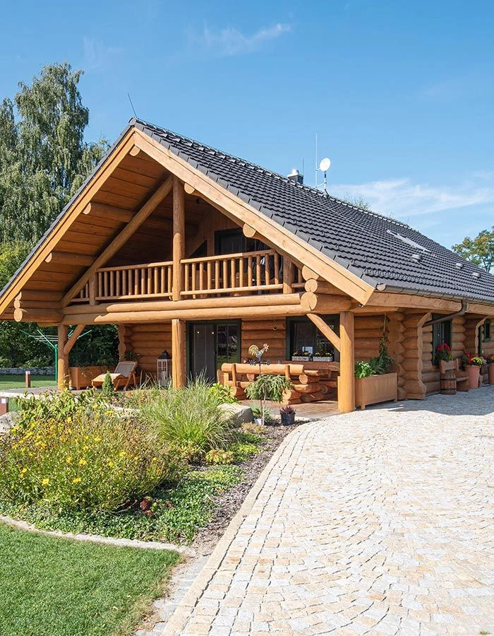Moderní roubená stavba s terasou a zahradním pozemkem.