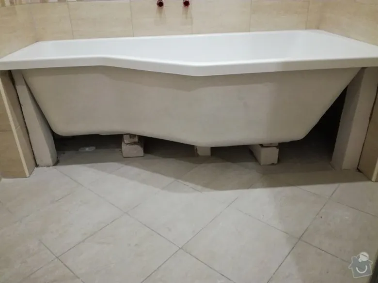 Bílá vana je instalována na podložkách ve stavební fázi.