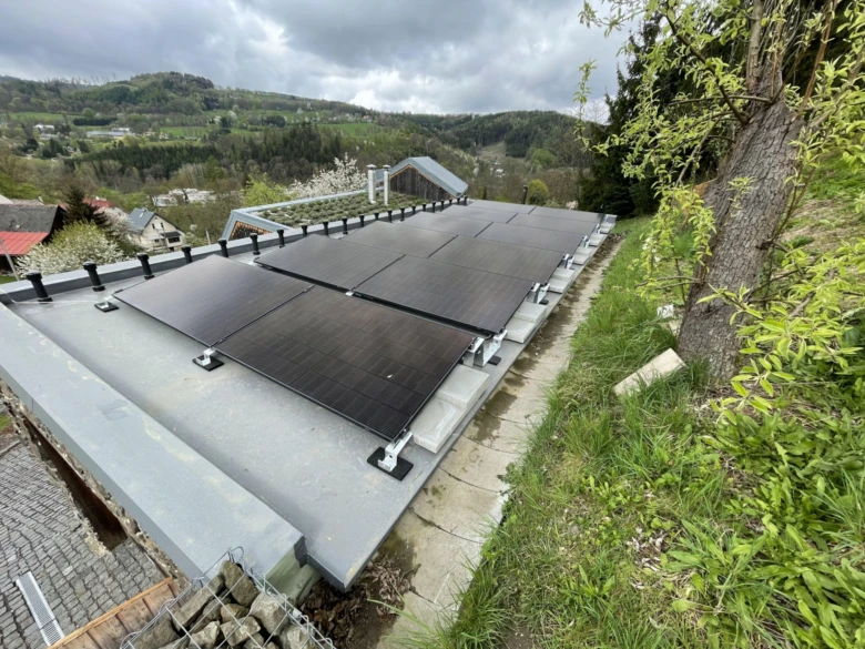 Fotovoltaické panely na střeše rodinného domu v přírodě.
