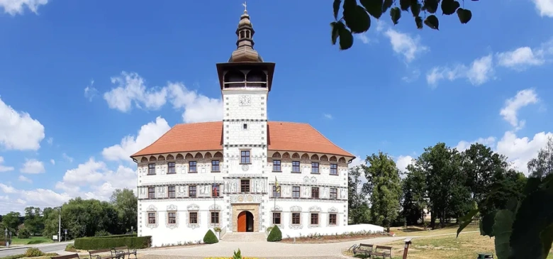 Zámek s keramickou střešní krytinou na modré obloze