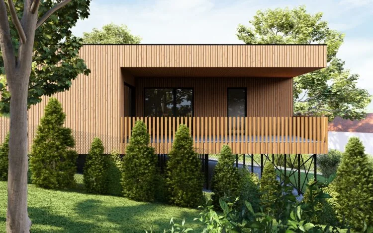 Moderní dřevěný modulární dům na sloupech v zeleném prostředí.