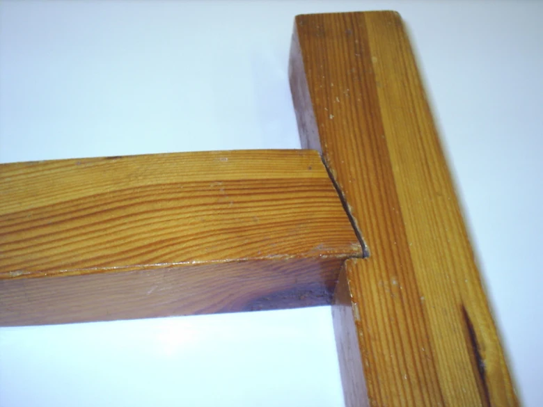 Detail dřevěného spoje dvou trámů v koutu konstrukce.