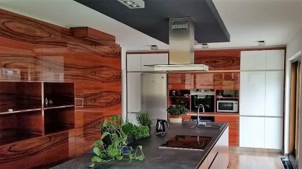 Moderní kuchyně s digestořem nad varnou deskou.