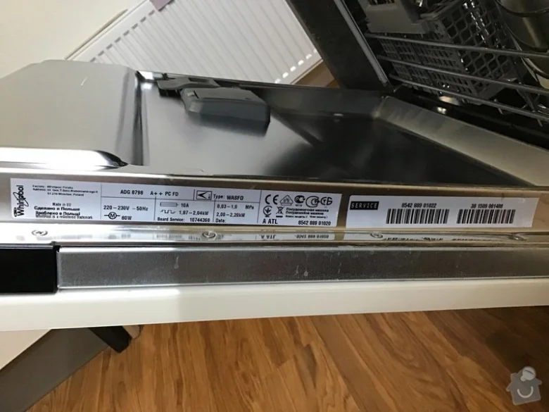 Blízký záběr na servisní štítek myčky nádobí značky Whirlpool.